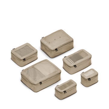 This is a photo of a set of six compressible packing cubes in tan