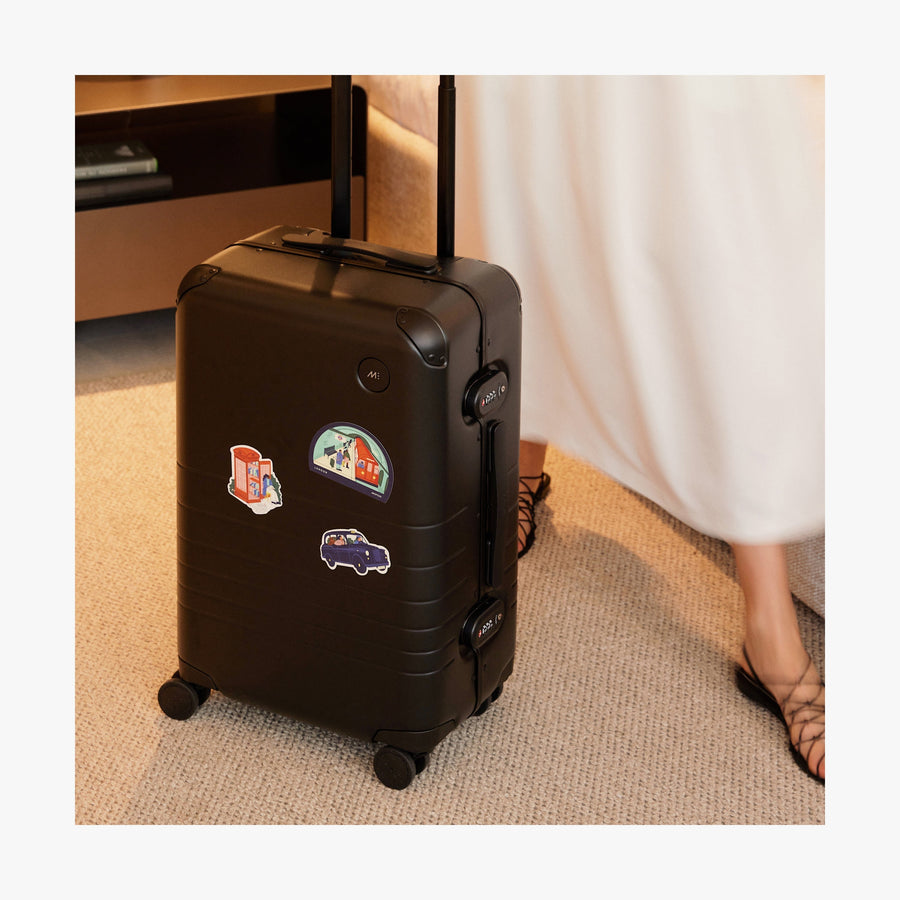 London | All three Destination Stickers  of London stickers set on a standing Black suitcase