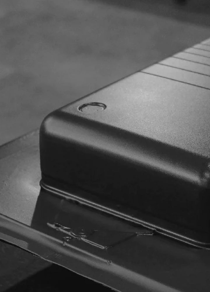 A close-up black and white photograph of one of our Monos Carry-On luggage pieces during the manufacturing process.